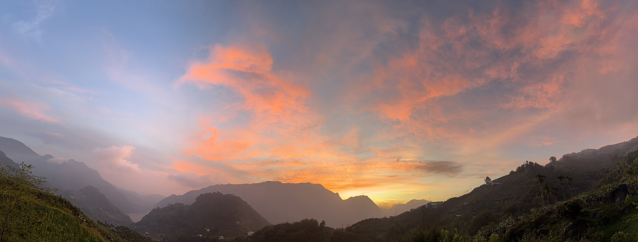 山裡天然攝影棚的橘紅夕陽與群山全景